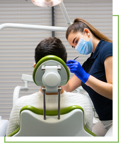 A woman dressed as a dental health worker holds dental tools up to a patient